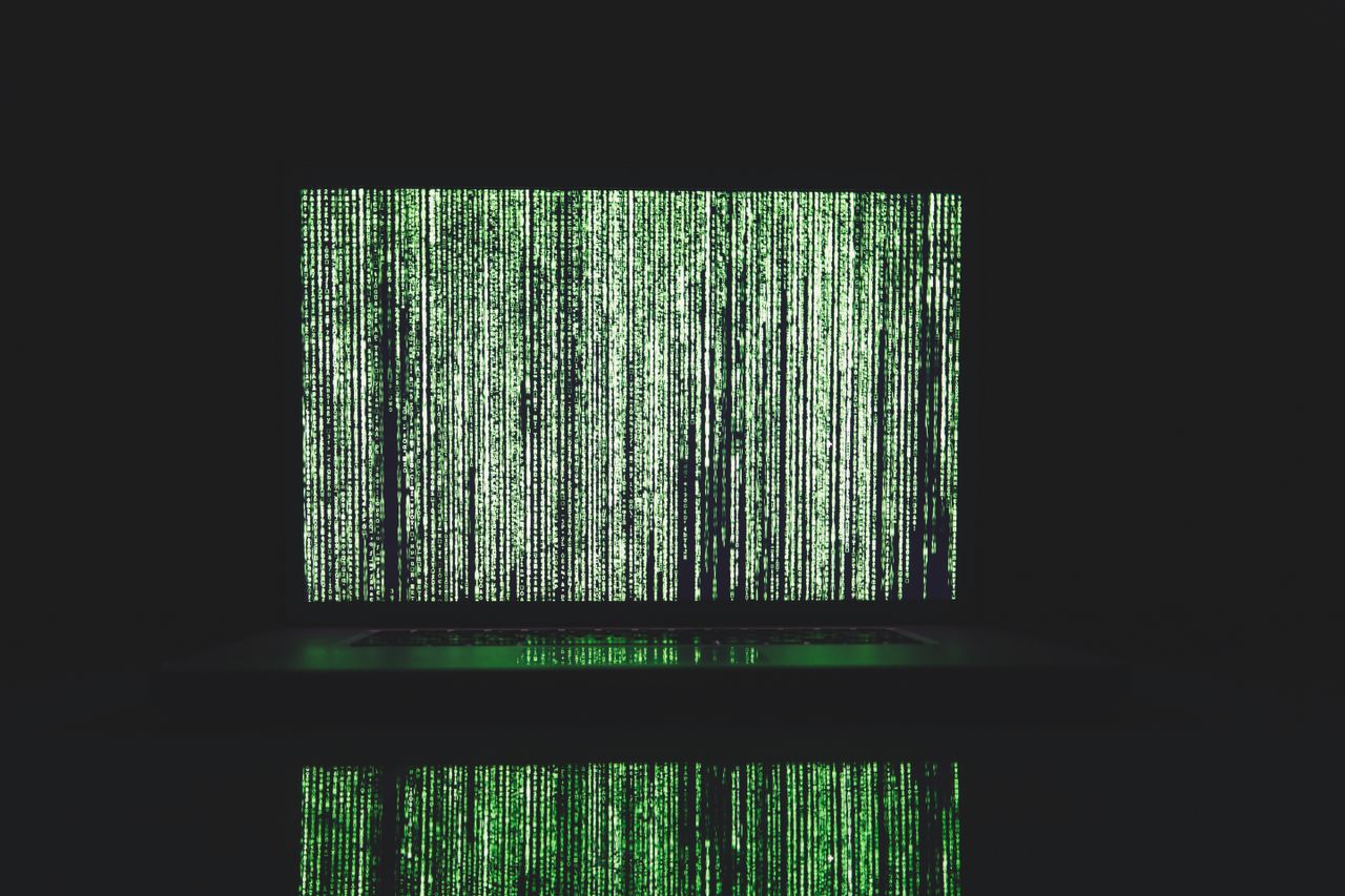 Abstract depiction of green matrix code on a computer monitor.